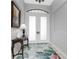 Elegant entryway with double doors, a console table, and patterned rug at 386 Royal Poinciana, Punta Gorda, FL 33955