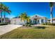 Single-story home with a stone facade, two-car garage, and manicured lawn at 386 Royal Poinciana, Punta Gorda, FL 33955