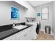 Bright laundry room with white cabinets, granite countertops, and a window at 386 Royal Poinciana, Punta Gorda, FL 33955
