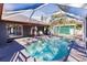Inviting freeform pool with a spa, screened enclosure, and a view of the home at 5188 Balmor Ter, North Port, FL 34288