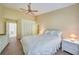 Bedroom with high ceiling, wood-look floors, and white wicker furniture at 8382 Creekview Ln, Englewood, FL 34224