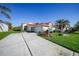 Single-story home with tile roof, attached garage, and landscaped yard at 8382 Creekview Ln, Englewood, FL 34224