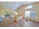 Living room with vaulted ceiling, wood-look floors, and sliding doors at 8382 Creekview Ln, Englewood, FL 34224