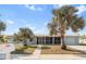 Light blue single story home with palm trees and screened porch at 174 Severin Se Rd, Port Charlotte, FL 33952