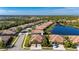 Aerial view of a house in a residential neighborhood near a lake at 2427 Daisy Dr, North Port, FL 34289