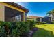 Partial view of backyard with hedges and a screened enclosure at 2427 Daisy Dr, North Port, FL 34289