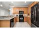 View of kitchen with wood cabinets, granite counters, and black appliances at 2427 Daisy Dr, North Port, FL 34289