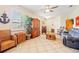 Spacious living room with tile floors, wicker furniture, and a ceiling fan at 25554 Prada Dr, Punta Gorda, FL 33955