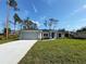 Newly constructed home with a gray exterior, two-car garage, and well-manicured lawn at 3672 Vehlin St, North Port, FL 34286