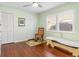 Bedroom with wood floors, a rocking chair, and plantation shutters at 3818 Bordeaux Dr, Punta Gorda, FL 33950