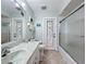 Clean bathroom with marble vanity, walk-in shower, and door to backyard at 4365 Aladdin Ave, North Port, FL 34287