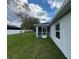 View of the home's exterior from the spacious backyard, featuring a screened-in lanai at 6356 Opa Locka Ln, North Port, FL 34291