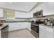 This kitchen features granite countertops, stainless steel appliances, and white cabinetry at 6356 Opa Locka Ln, North Port, FL 34291