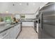 Modern kitchen featuring a stainless steel refrigerator, granite countertops and white cabinets at 6356 Opa Locka Ln, North Port, FL 34291