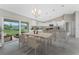 Well-lit kitchen and dining area featuring modern white cabinets and a sliding glass door at 6356 Opa Locka Ln, North Port, FL 34291