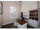 Home office with a desk, built-in shelves, and large window with plantation shutters at 10361 Redondo St, Port Charlotte, FL 33981