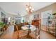 Bright dining room with glass-top table and four chairs, chandelier, and view into living area at 17094 Acapulco Rd # 313, Punta Gorda, FL 33955