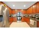 Kitchen with wood cabinets, granite counters, and stainless steel appliances at 17094 Acapulco Rd # 313, Punta Gorda, FL 33955
