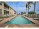 Community pool with lounge chairs and palm trees at 17094 Acapulco Rd # 313, Punta Gorda, FL 33955