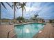 Community pool with lounge chairs and palm trees at 17094 Acapulco Rd # 313, Punta Gorda, FL 33955