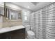 Bathroom with dark vanity, shower, and patterned curtain at 22481 Vale Ave, Punta Gorda, FL 33980