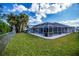 Spacious backyard with a screened pool and lush lawn at 23176 Lindale Ave, Port Charlotte, FL 33954