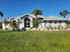 Charming single-story home featuring a bright lawn, beautiful palm trees, and gorgeous curb appeal at 23176 Lindale Ave, Port Charlotte, FL 33954