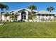 Inviting single-story home featuring a bright lawn, beautiful palm trees, and gorgeous curb appeal at 23176 Lindale Ave, Port Charlotte, FL 33954