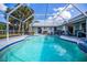 Inviting pool area with screened enclosure, comfortable seating, and grill at 23176 Lindale Ave, Port Charlotte, FL 33954