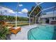 Relaxing poolside view with wicker chairs and lush greenery at 23176 Lindale Ave, Port Charlotte, FL 33954