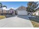 House with a two-car garage and driveway, surrounded by lush landscaping at 25017 Lalique Pl, Punta Gorda, FL 33950