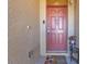 Red front door with a welcome mat, adding a touch of charm to the entryway at 25017 Lalique Pl, Punta Gorda, FL 33950