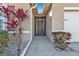 Front entry with a security gate and walkway, flanked by tropical plants at 25017 Lalique Pl, Punta Gorda, FL 33950
