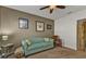 Relaxing living room featuring a teal couch, framed artwork, and a ceiling fan at 25017 Lalique Pl, Punta Gorda, FL 33950