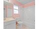 Pink bathroom with white bathtub, toilet and sink at 2606 Trilby Ave, North Port, FL 34286