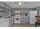 Condo kitchen with white appliances and gray cabinets at 3310 Loveland Blvd # 701, Punta Gorda, FL 33980