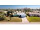 Aerial view of a one-story turquoise home, featuring a long driveway and manicured lawn at 10129 Edmonton Ave, Englewood, FL 34224