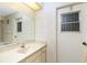 Neutral bathroom featuring a vanity with a sink, a large mirror, and a door to the backyard at 10129 Edmonton Ave, Englewood, FL 34224