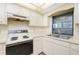 Cozy kitchen featuring white cabinets, laminated countertops, and traditional appliances at 10129 Edmonton Ave, Englewood, FL 34224