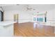 Open living area with wood flooring, bay window, ceiling fan, and view into adjacent dining space at 10129 Edmonton Ave, Englewood, FL 34224