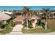 Single-story home with a brown garage door, landscaping, and palm trees at 1110 Rum Cay Ct, Punta Gorda, FL 33950