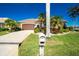 Front view of a single-story house with a two-car garage and mature landscaping at 1110 Rum Cay Ct, Punta Gorda, FL 33950