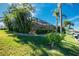 Back exterior view showcasing a screened lanai and lush landscaping at 1110 Rum Cay Ct, Punta Gorda, FL 33950