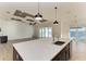 Kitchen island with quartz countertop, farmhouse sink, and breakfast bar overlooking the living room at 112 Northshore Ter, Punta Gorda, FL 33980