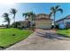 Two-story house with tile roof, palm trees, and a brick paved driveway at 1245 Whippoorwill Ct, Punta Gorda, FL 33950