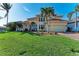 Front view of two-story house with tile roof, lush landscaping, and driveway at 1245 Whippoorwill Ct, Punta Gorda, FL 33950