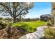 Landscaped backyard with pond view and large tree at 13761 Long Lake Ln, Port Charlotte, FL 33953