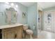 Bathroom with a decorative mirror, vanity, toilet, and tiled walk-in shower with a glass door at 13761 Long Lake Ln, Port Charlotte, FL 33953