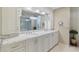 Bathroom with double sinks, granite countertops, and a luxurious glass-enclosed shower with decorative lighting at 13761 Long Lake Ln, Port Charlotte, FL 33953