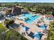 Aerial view of a community pool with ample seating, umbrellas, and well-maintained landscaping for residents to enjoy at 13761 Long Lake Ln, Port Charlotte, FL 33953